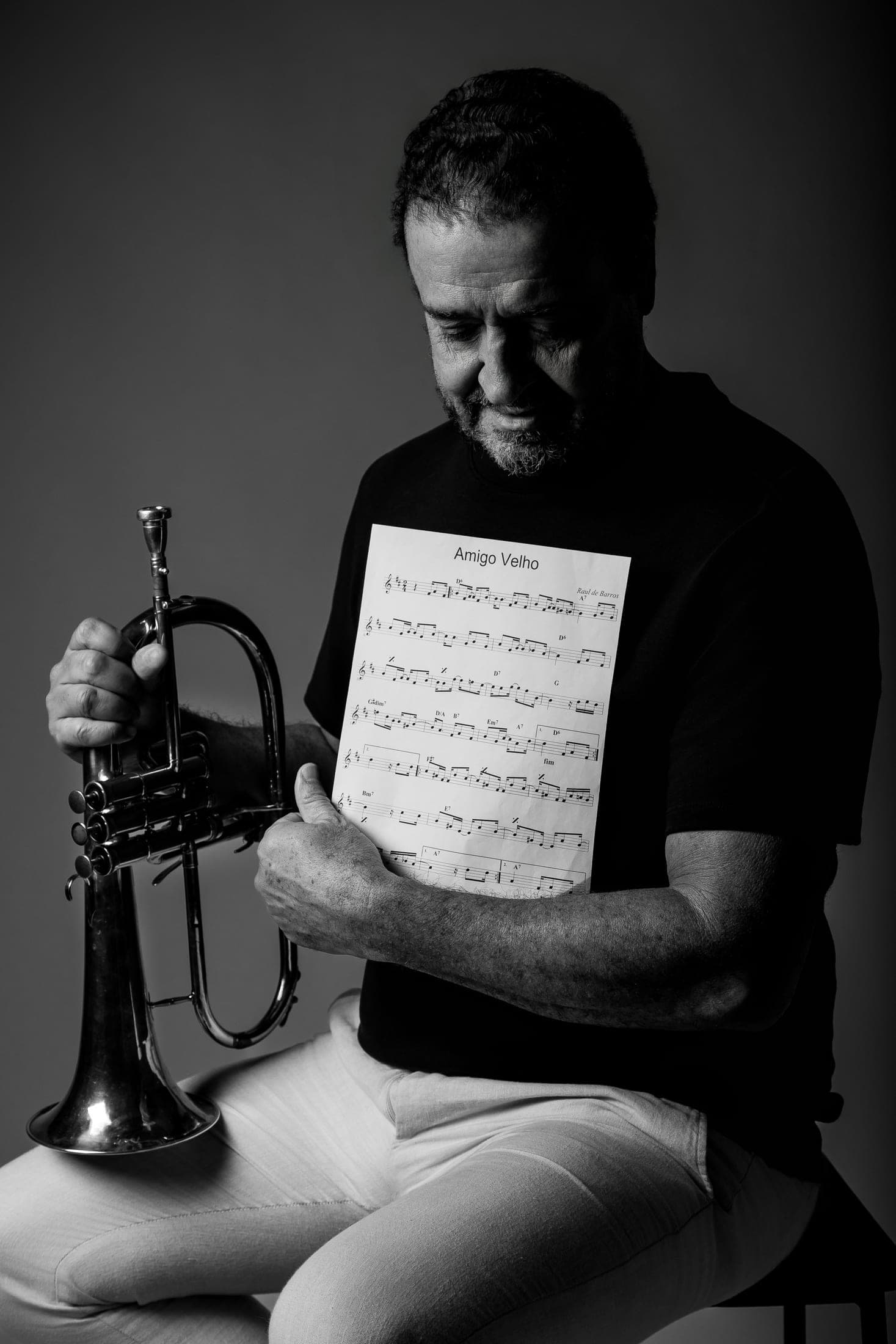Silvério Pontes lendo uma partitura ao lado do flugelhorn, em preto e branco